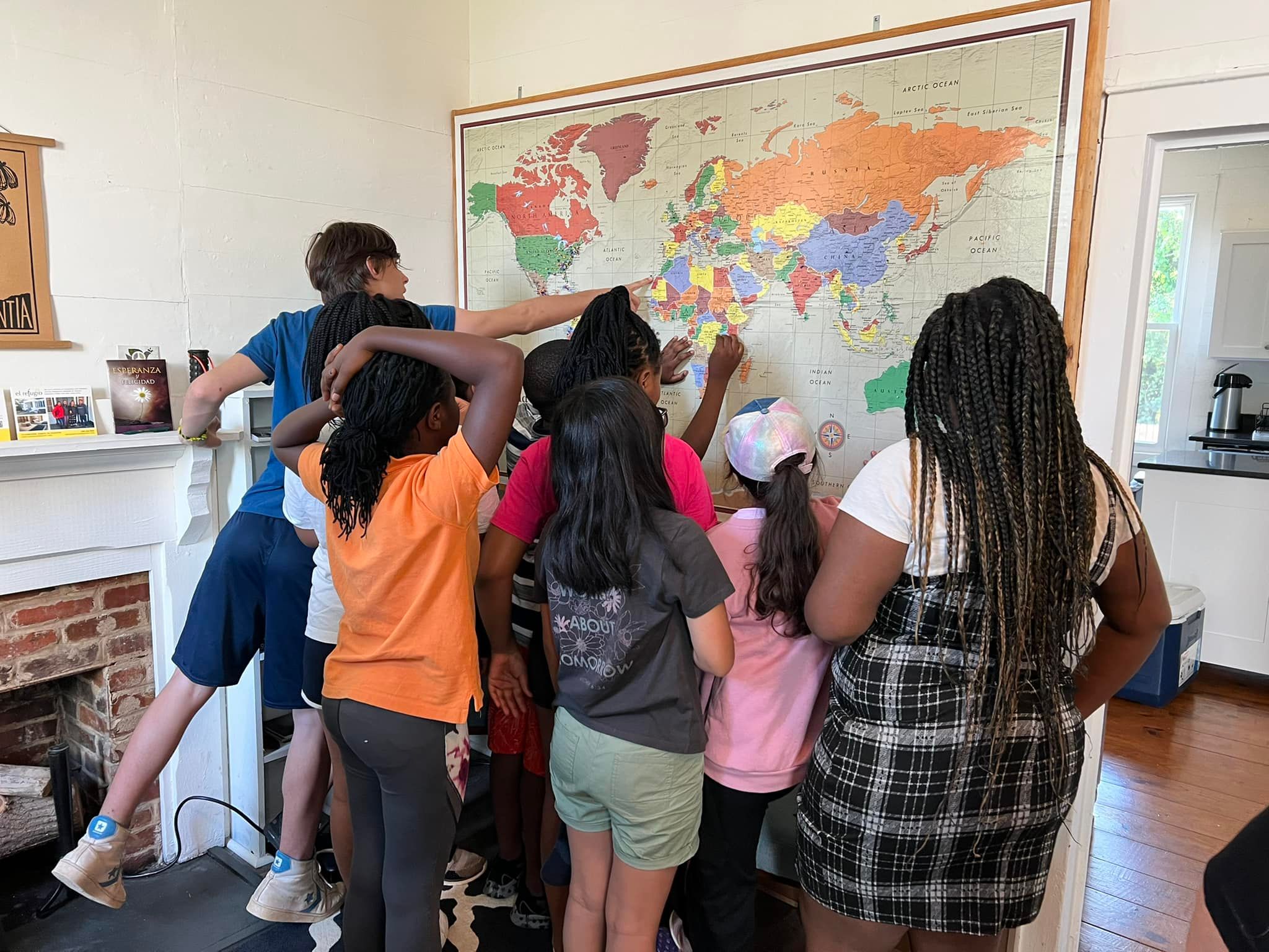 a group of young people pointing at a map on the wall